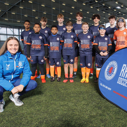 A group of young footballers at Rangers FC International Soccer Academy with their coach